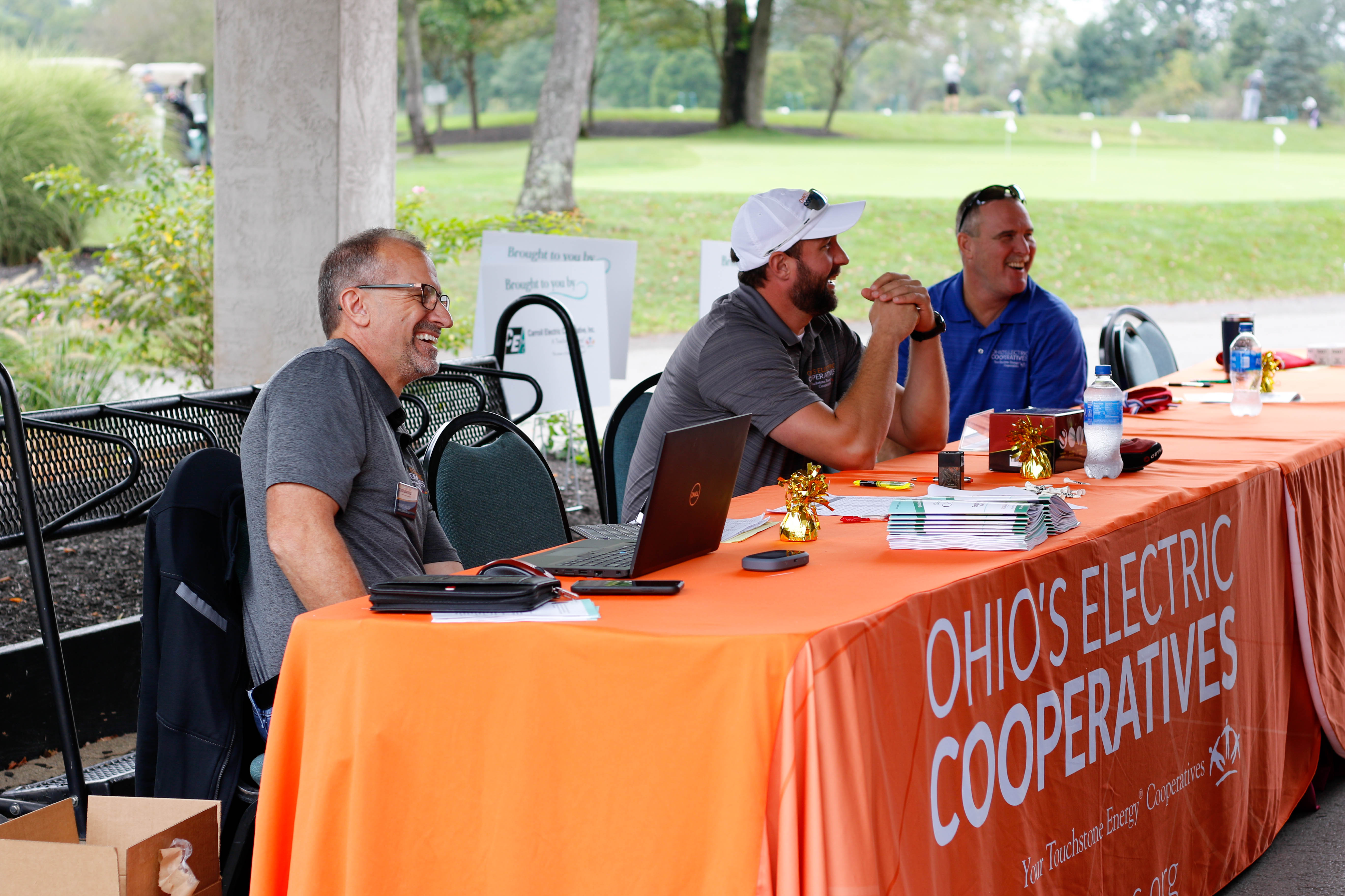 A man smiling with others at an event's registration table