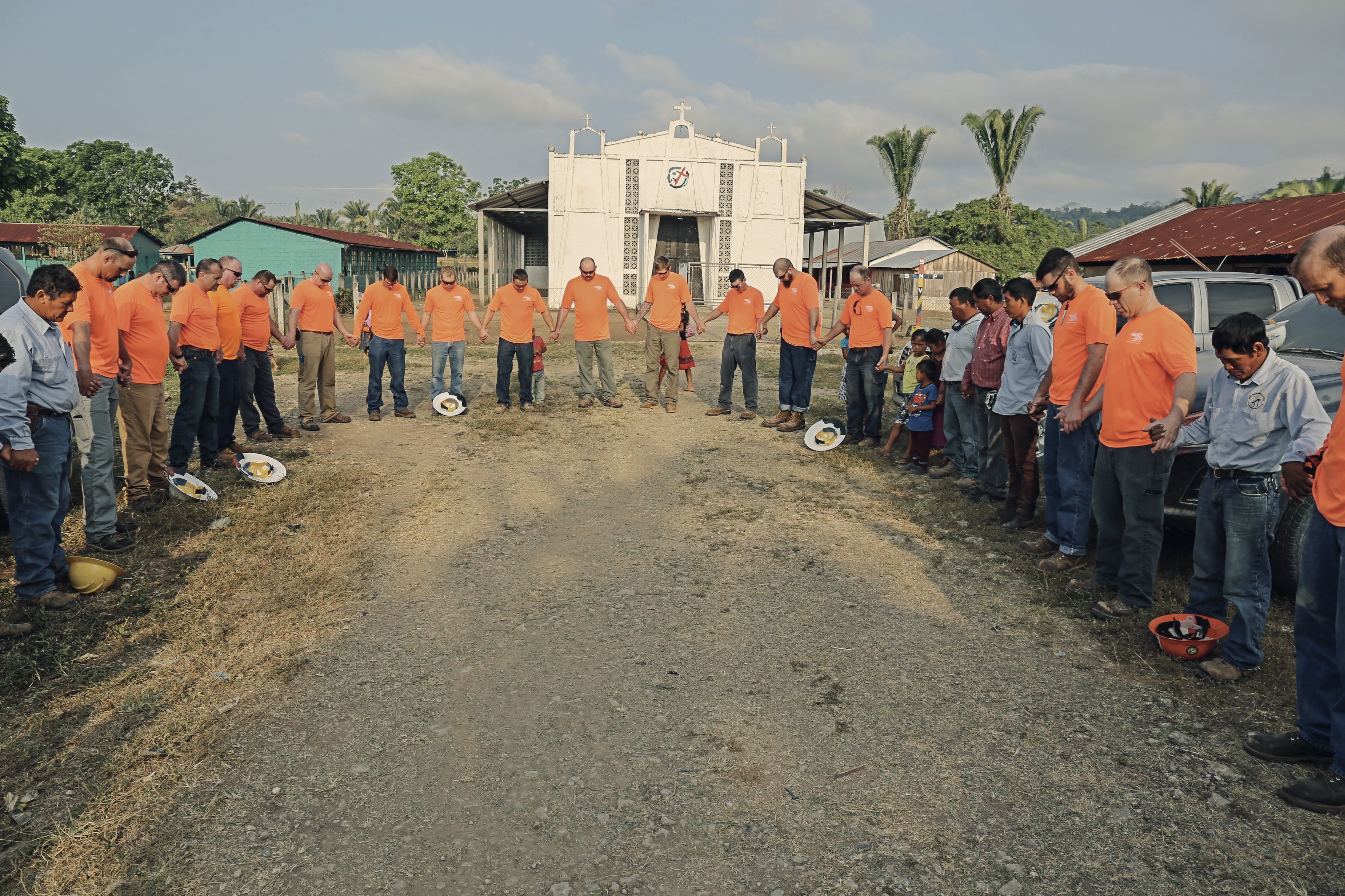 A large group of people praying in a circle