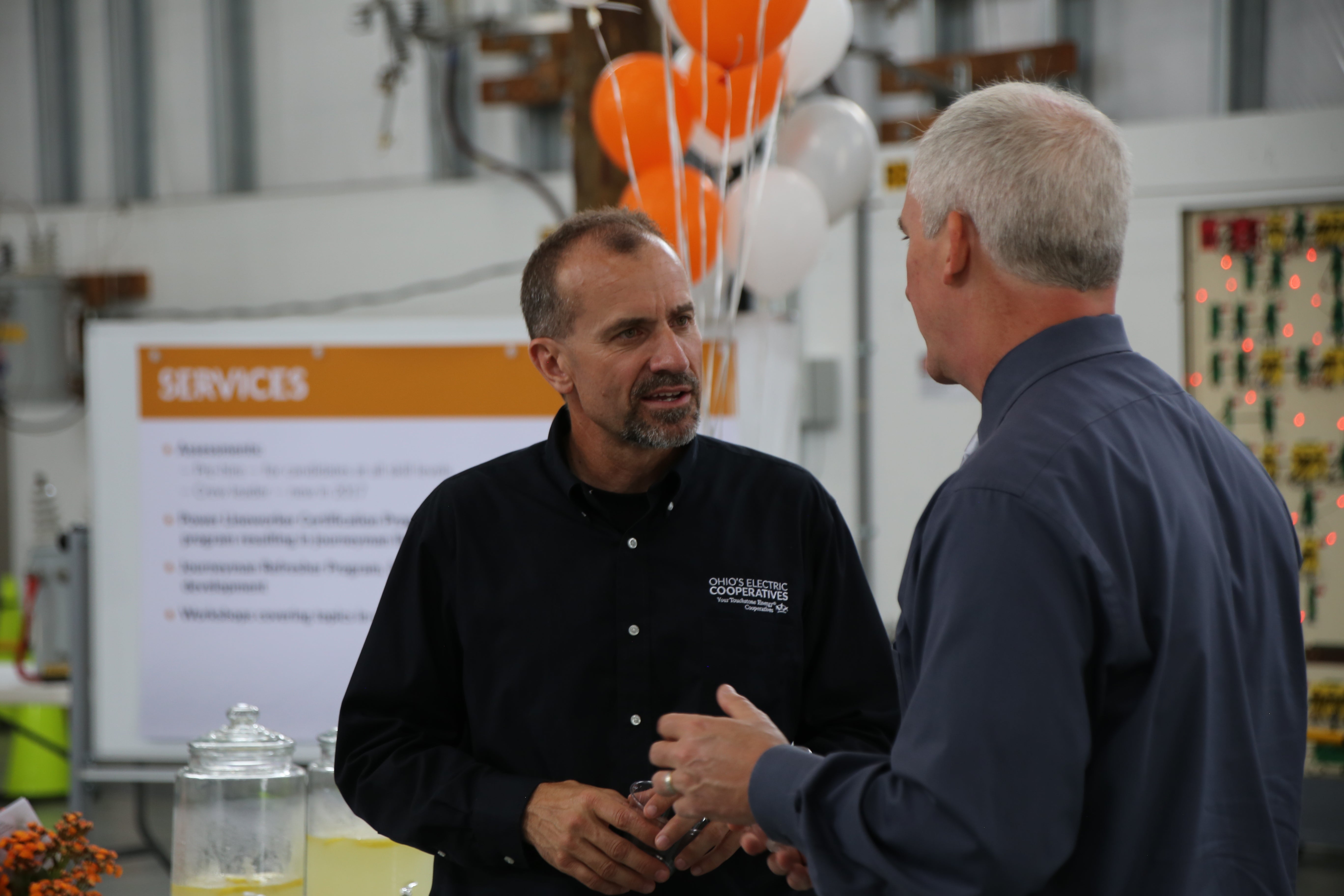 Two people talking at an open house celebration